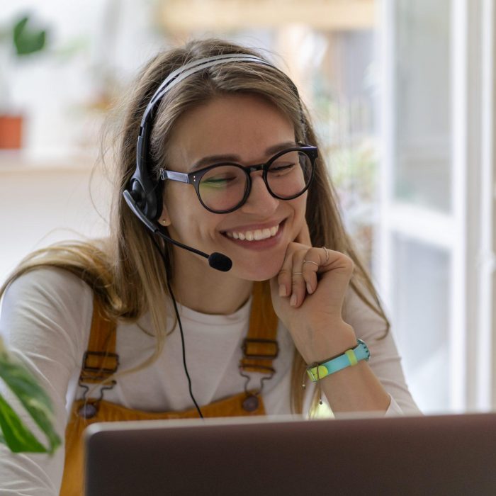 Smiling gardener millennial woman wear headphones talk video cal
